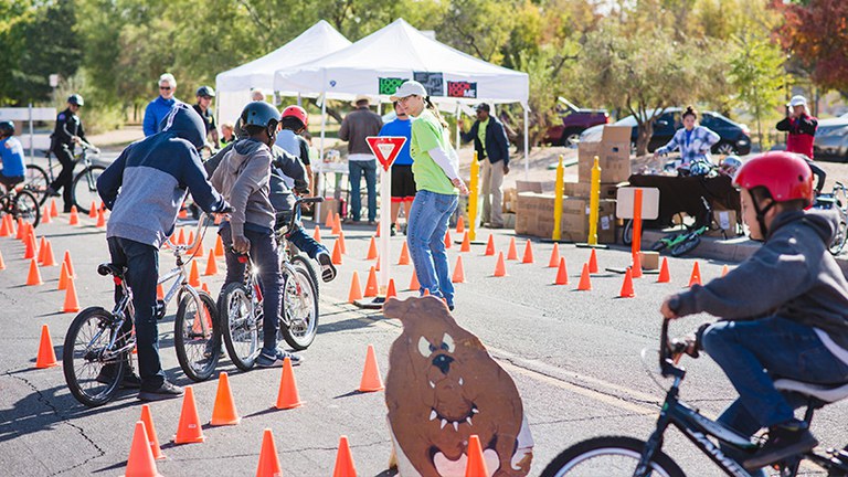 Youth riding bikes while adults observe and give instruction