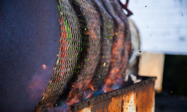 A close up of a green chile roaster.